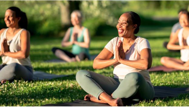 women doing yoga outside on a sunny day